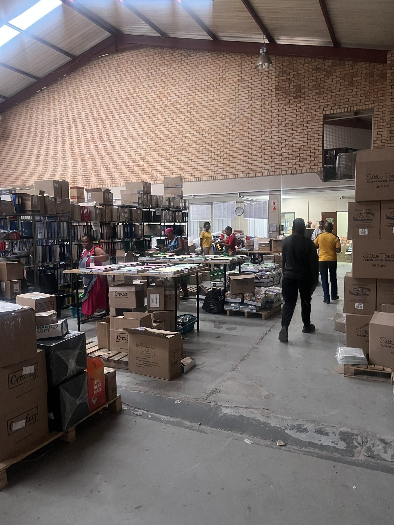 The Akasia warehouse, with staff packing stationery orders at long tables.